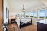 Downstairs bedroom with queen bed and ocean views at Sunset Cove